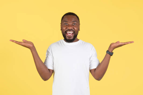 istock Excited Black Millennial Man Shrugging Shoulders Over Yellow Background 1475329863