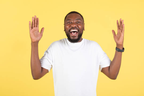 istock Excited Black Man Shouting In Joy Raising Arms, Yellow Background 1475330295