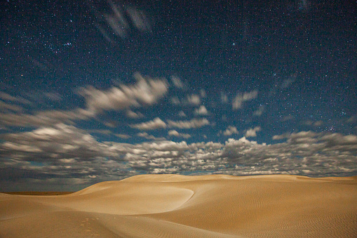 Remote arid desert sand dunes by the coast at night with stars. Photographed in South Australia.