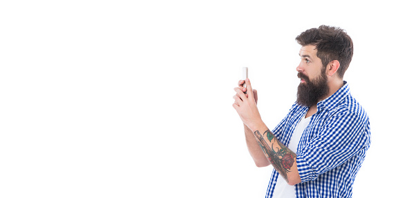 amazed brutal bearded man taking picture with phone isolated on white background with copy space.
