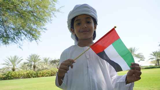 Emirati child wearing traditional kandura white dress from Arab emirates