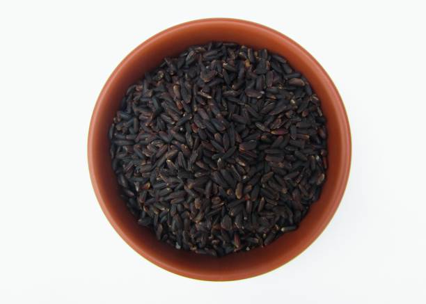 istock Black rice in a bowl on white background top view 1475341527