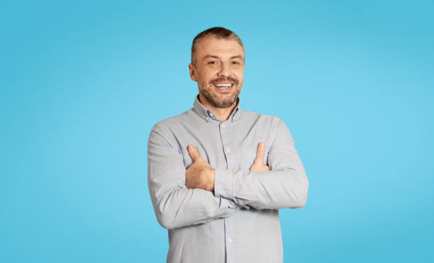 istock Happy Mature Male Smiling To Camera Standing On Blue Background 1475342072