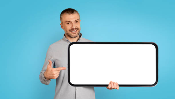istock Cheerful Man Holding Large Smartphone With Empty Screen, Blue Background 1475342502