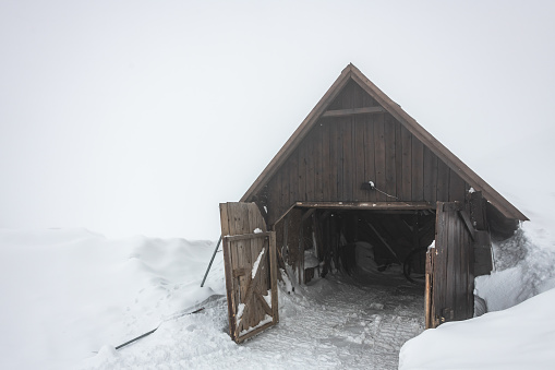 Wooden shed in very deep snow