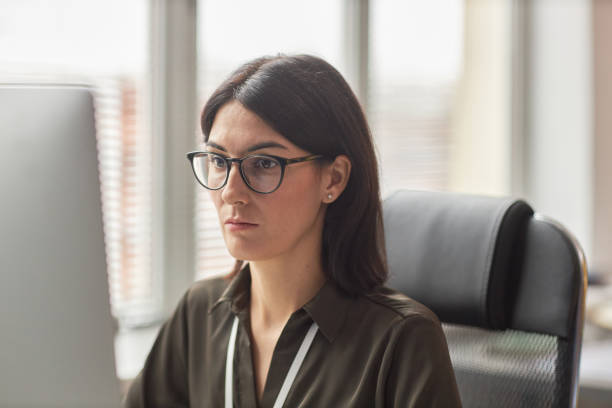 istock Focused businesswoman wearing glasses using computer at workplace 1475344726
