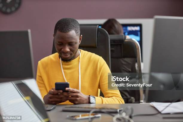 Dark Software Developer Black Software Developer Using Smartphone At Office Desk Stock Photo ...