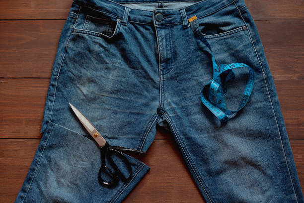 istock Upcycle old denim garbage. Recycling old jeans. Stack of old blue jeans, cut pieces ready for recycling and scissors. Circular economy. Pile of discarded old blue jeans. Zero waste 1475349315
