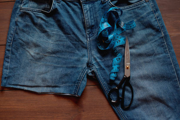 istock Upcycle old denim garbage. Recycling old jeans. Stack of old blue jeans, cut pieces ready for recycling and scissors. Circular economy. Pile of discarded old blue jeans. Zero waste 1475349466