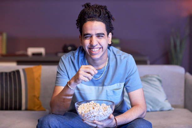 istock Man eating popcorn at home 1475352205
