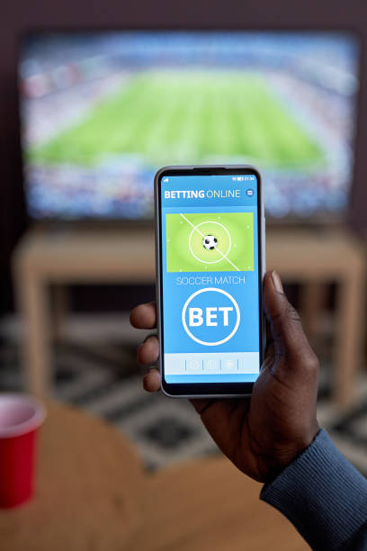 closeup of male hand holding smartphone with online sports bets - fan sport football male imagens e fotografias de stock