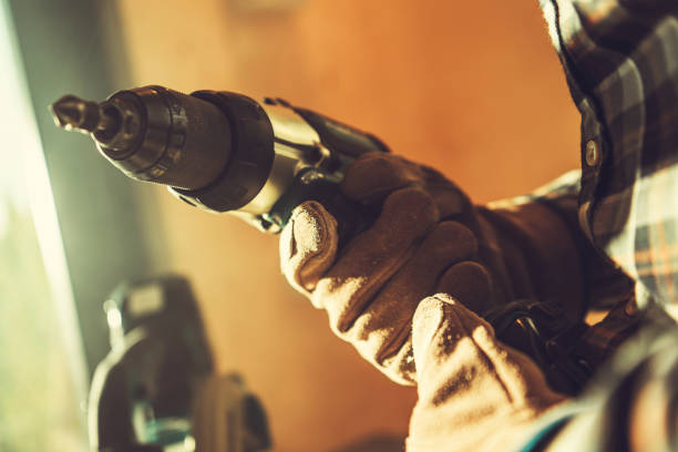 istock Worker with Drill Driver in His Hand Close Up 1475352401