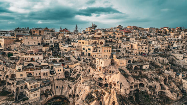 Uçhisar is a village in Cappadocia, in Nevşehir province, Turkey. It is 7 kilometres east of Nevşehir, 12 kilometres west of Ürgüp, and 10 kilometres south of Avanos. Situated on the edge of Göreme National Park, Uçhisar consists of an old village huddled around the base of a huge rock cone and a new one closer to the road that runs from Nevşehir town to Göreme. vista aérea de uchisar, vista aérea de capadocia, castillo de uçhisar, lugar famoso de turquía, chimeneas de hadas de formación natural, destino del patrimonio de la unesco, vista aérea de capadocia, región histórica en anatolia central, antiguo as