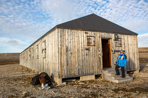 Single middle aged woman visiting an abandoned scientific research station in Svalbard.