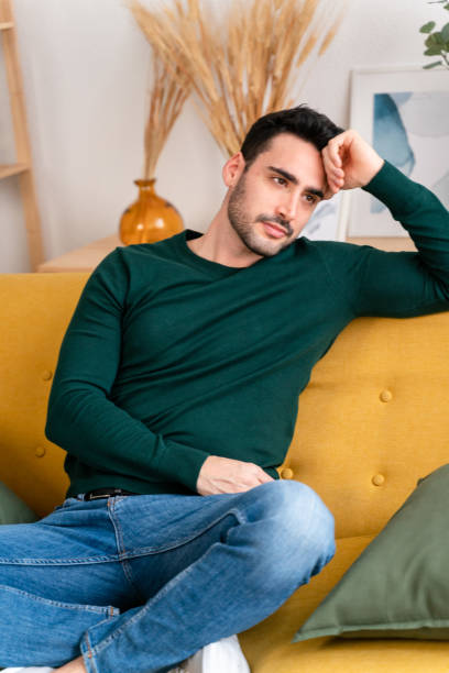 istock Cheerful man sitting on sofa 1475354004