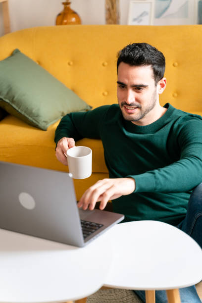 istock Man with cup of coffee working on laptop 1475358249
