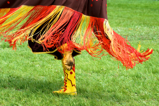 The fringe and moccasins of a fancy shawl dancer at a powwow