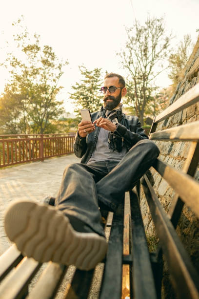 istock Young man uses a smartphone outdoors on a sunny day. 1475359780