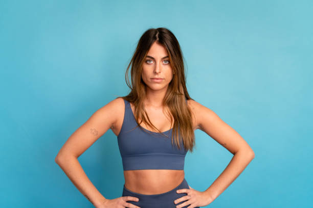 istock Smiling sportswoman with hands on waist in studio 1475360001
