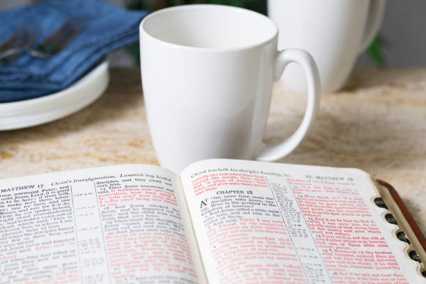 Friends share coffee and a snack as they study the Bible together.  Blue Napkins on marble top table.