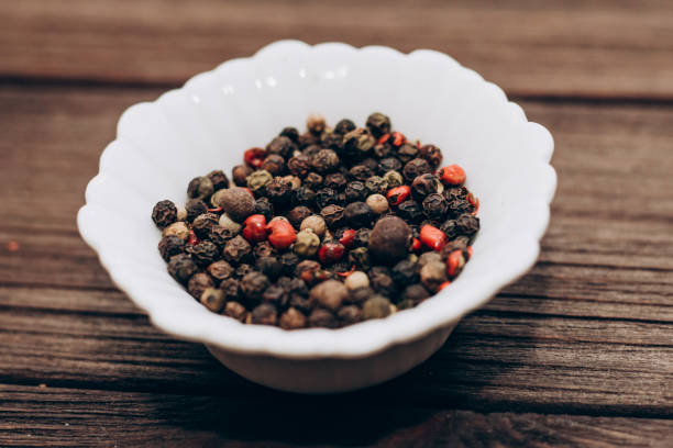 istock Black, fragrant, red pepper spices in bowls on a wooden table 1475362663