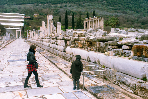 View of a mother and son near antique columns in Library of Celsus. \nEphesus ancient city, Turkey.
