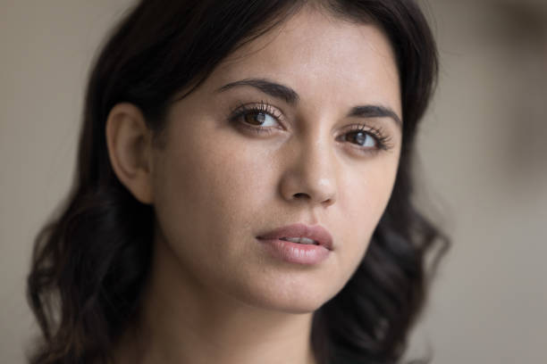 istock Serious Asian woman looking at camera with thoughtful face 1475369342
