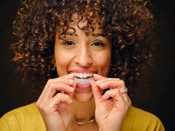 Jeune femme heureuse tenant des gouttières de dents invisibles - Photo