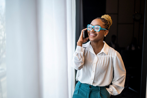 Retrato de una empresaria negra sonriente hablando por teléfono photo