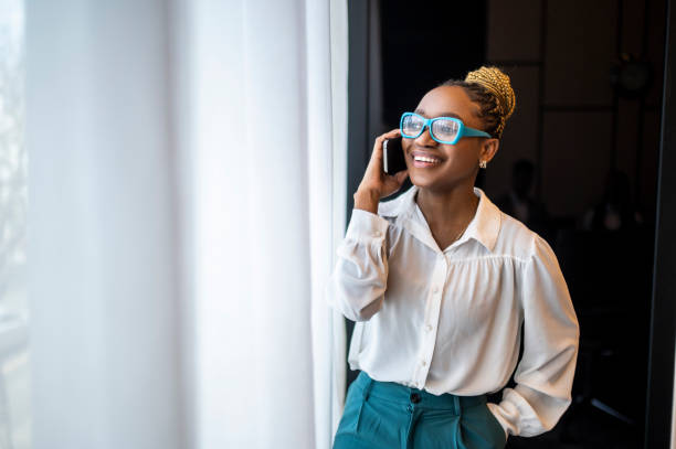 Portrait of a smiling black female entrepreneur talking on the phone stock photo