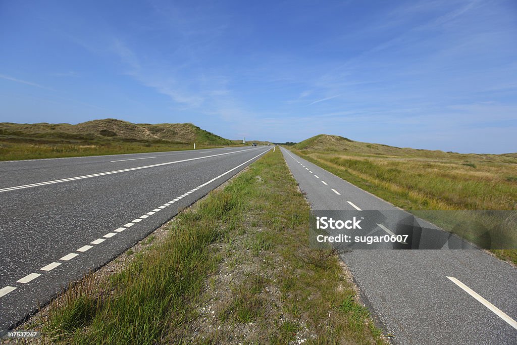 Straight, flat road landscape with a bicycle lane Straight, flat road landscape with a bicycle lane in Scandinavia Asphalt Stock Photo