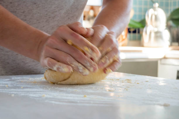 istock Woman kneading dough on kitchen counter 1475373950