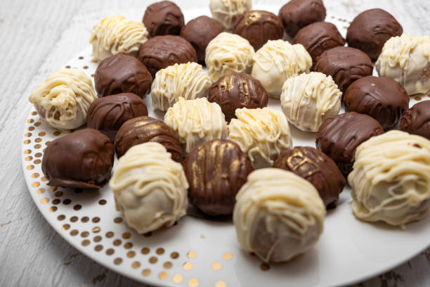 Chocolate truffles on plate on white table. stock photo