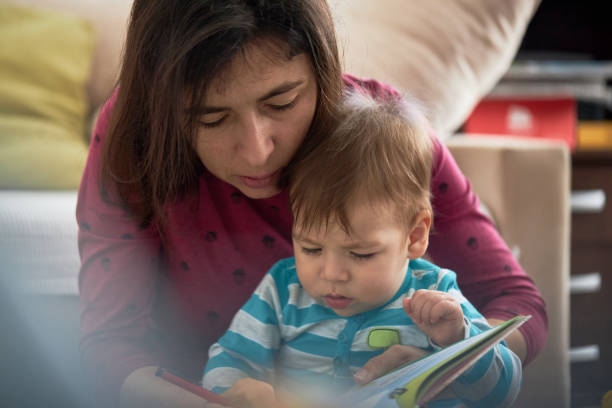istock Mother And Baby Son Reading Book Together 1475375684