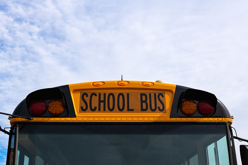 A fleet of school buses leave an elementary school after morning drop offs.