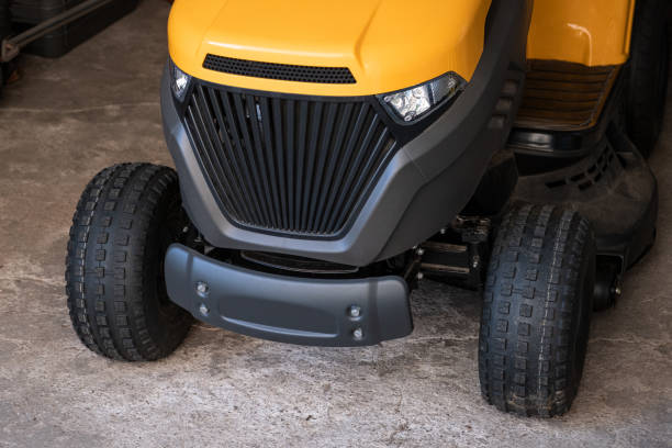 szczegóły ogólnego żółtego minitraktora do kosiarki do prac ogrodowych, stoją w garażu na farmie. zbliżenie sprzętu ogrodniczego - rotary mower zdjęcia i obrazy z banku zdjęć