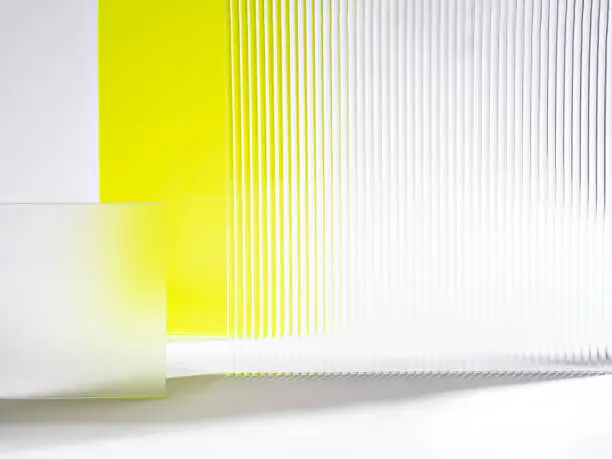 Abstract  showcase podium. Acrylic glass making transparent and ribbed structures of white and pastel yellow. The stage is perfect for advertising beauty products, decorations, makeup and accessories.