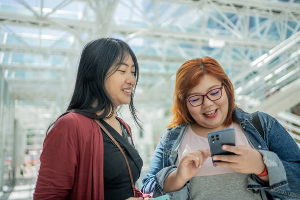 istock Two Japanese female friends using smartphone at the mall 1475390596