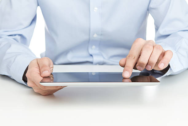 istock Young adult wearing light blue shirt working on a tablet 147539076