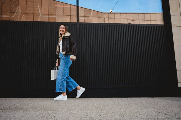 low angle view of a woman walking on a sidewalk.
