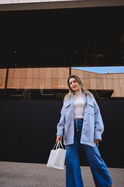 istock modern stylish female with a bag looking at camera. 1475391436