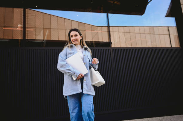 istock working woman with laptop walking outdoors. 1475391502