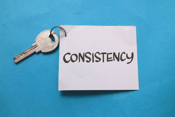 Consistency is the key, text words typography written on paper against blue background, life and business motivational inspirational