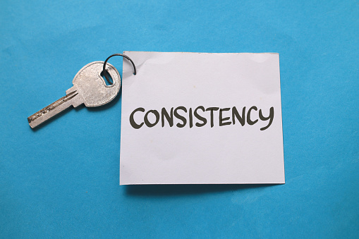 Consistency is the key, text words typography written on paper against blue background, life and business motivational inspirational