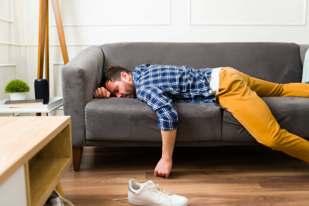 istock Tired young man resting and sleeping on the sofa 1475394872