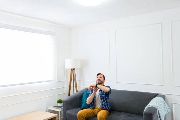 istock Cheerful man using technology on his smartwatch to control the lights at home 1475394912