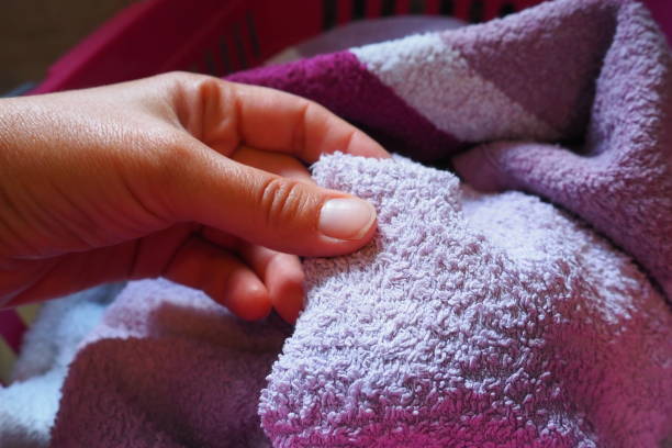 istock A woman's hand is feeling a cotton colored towel from a basket with dirty laundry. Laundry sorting and washing. Laundry room or bathroom. Housekeeping. Pink and blue terry towels. 1475402406