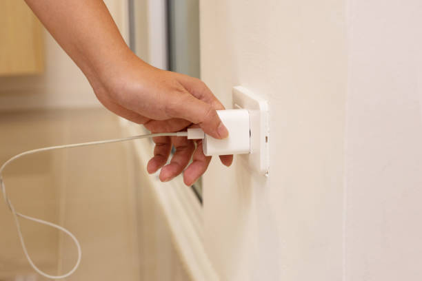 istock Hand insert a plug of the phone charger into socket. 1475408367