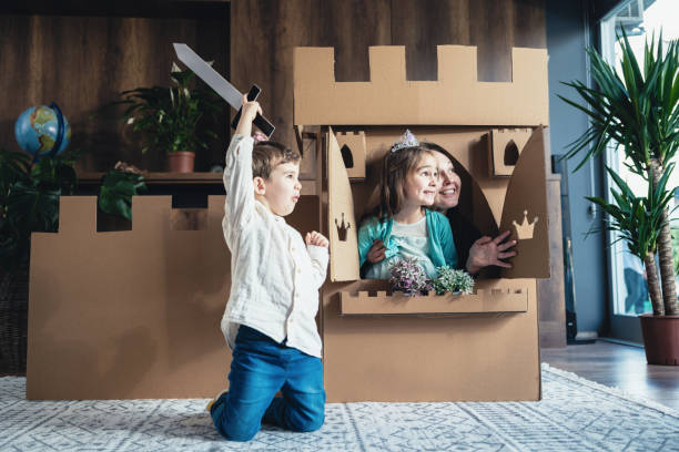 madre e hijos jugando juego de rol en casa con castillo hecho de cartón - princess castle child family fotografías e imágenes de stock