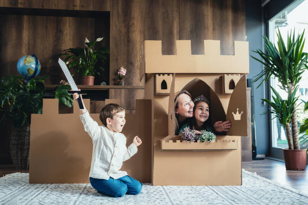 madre e hijos jugando juego de rol en casa con castillo hecho de cartón - princess castle child family fotografías e imágenes de stock